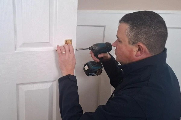 Locksmith dismantling a faulty door lock as part of a professional lock repair.