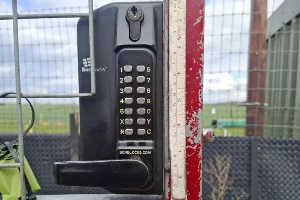 Mechanical keypad lock fitted to a metal gate during commercial locksmith work in Raunds