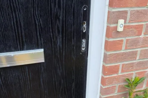 Composite entrance door with lock hardware removed during repair