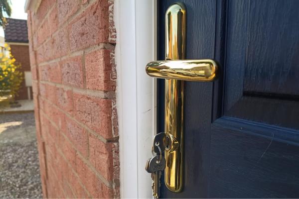 Gold entrance door handle and lock hardware fitted to a composite door