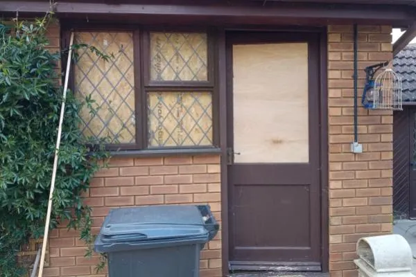 Exterior door securely boarded up after damage to the glazed panel