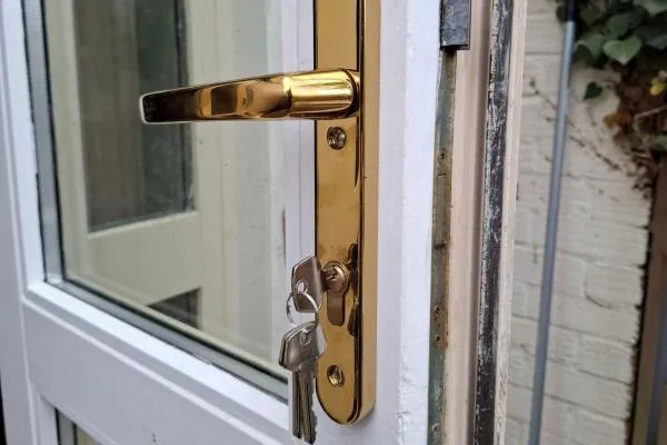 Emergency locksmith in Irchester repairing a uPVC door lock with keys in the cylinder.