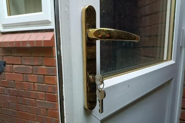 Keys in the lock of a white uPVC door after an emergency locksmith call-out in Wellingborough.