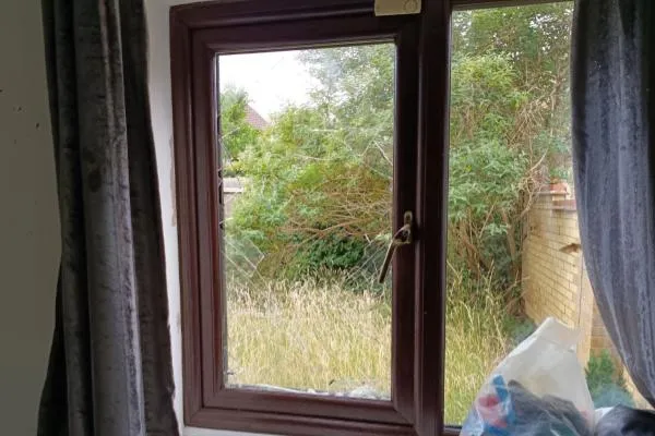 Damaged window glass awaiting replacement in a residential property