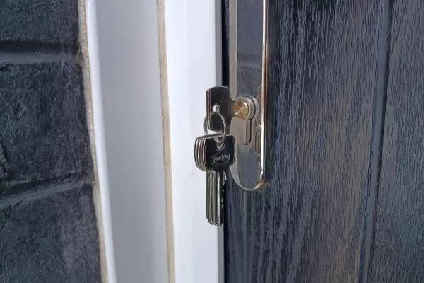 Keys in the lock of a composite front door, illustrating a home lockout service