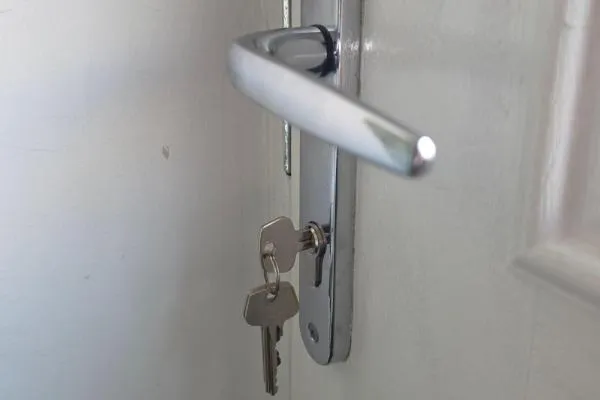 Irchester locksmiths repairing a uPVC door lock with keys and lever handle.