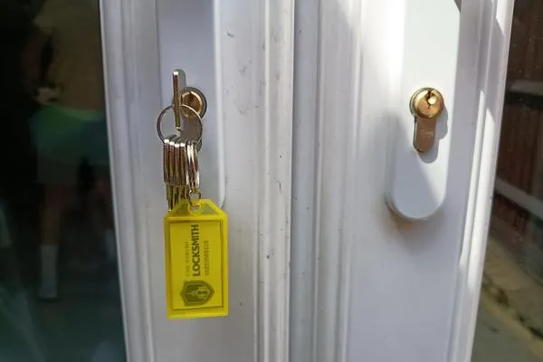 One set of keys beside two door lock cylinders