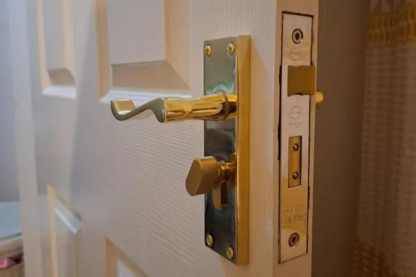 Brass lever handle and thumbturn lock fitted to a white internal door in Wellingborough.