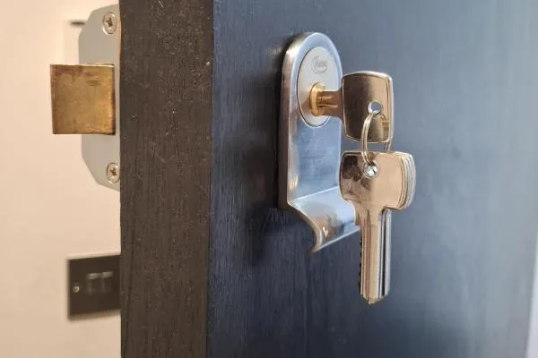 Keys in a repaired lock on a dark wooden door in Wellingborough.