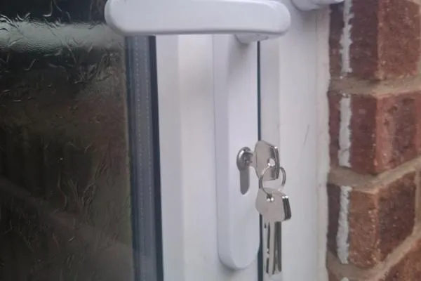 Locksmith in Bozeat replacing the lock and keys on a white uPVC door