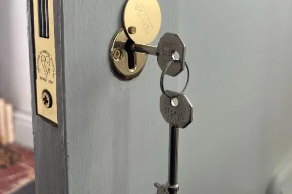 Mortice lock fitted to a wooden door with key inserted