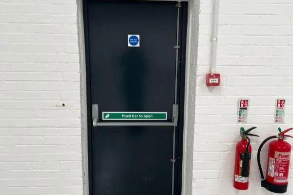 Panic bar fitted to a commercial fire-exit door