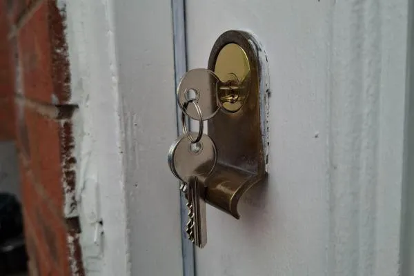 Rim cylinder fitted to a wooden entrance door with key inserted