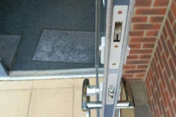 Alt text: Commercial door lock fitted to an aluminium framed door
