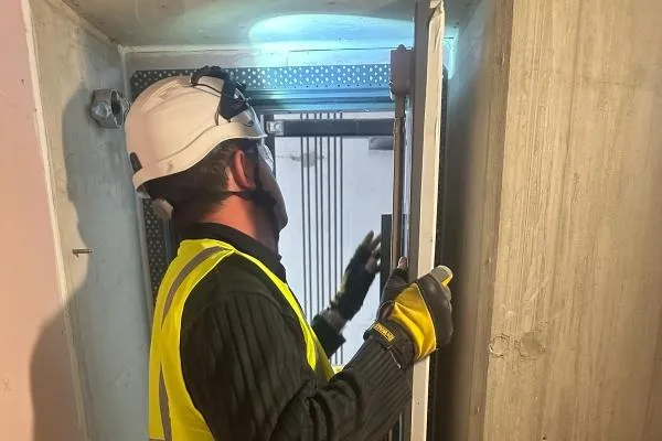 Commercial door specialist carrying out door repair and adjustment work