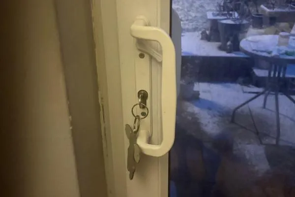 Handle, lock and keys on a white uPVC sliding door after a repair in Bozeat