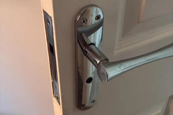 Broken bathroom door handle and latch prepared for repair in Finedon