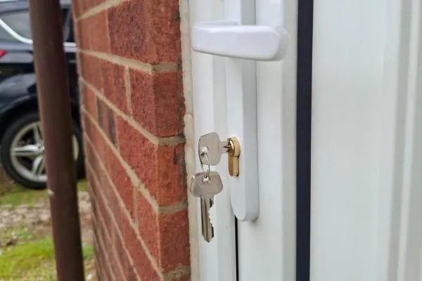 Brass lock and white handle on a uPVC shown after an emergency locksmith callout in Bozeat