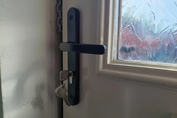 Door lock and handle with keys during locksmith work in Finedon
