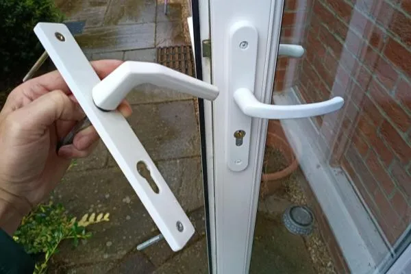 Old and new handles alongside a newly fitted lock on a door in Bozeat