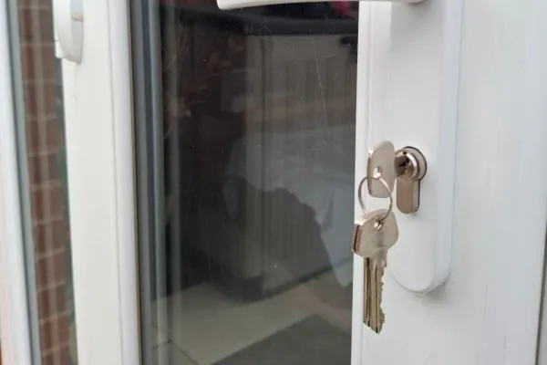 White handle and barrel with keys on a white patio door in Sharnbrook