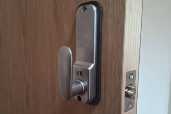 Silver mechanical digital combination door lock fitted to a wooden door, illustrating commercial locksmith services in Castle Ashby.