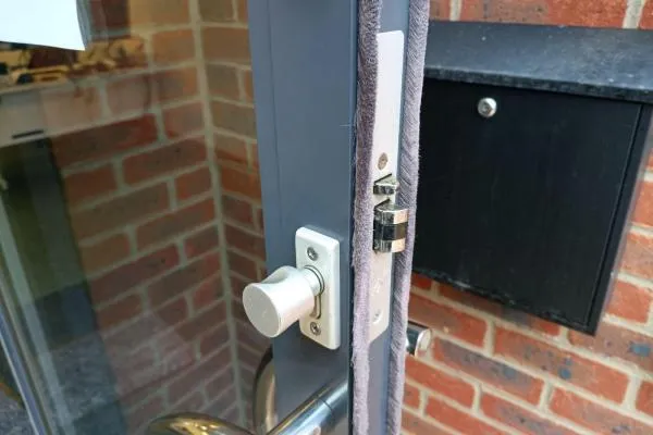 Commercial door fitted with a thumbturn lock and surface-mounted locking hardware.