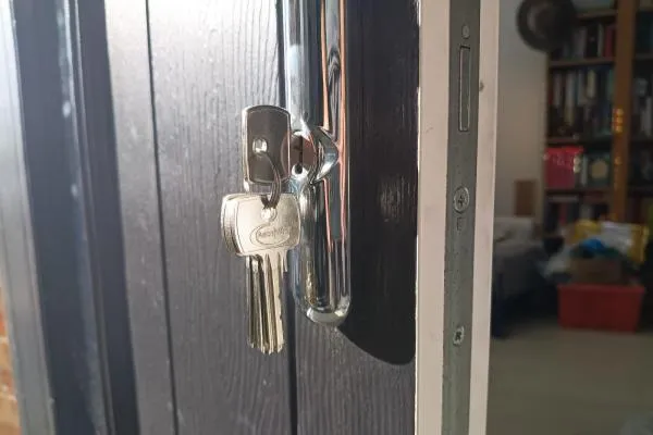 Euro cylinder lock with keys fitted to a dark composite door with chrome handle.