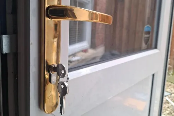 Gold door handle and euro cylinder lock fitted to a glazed uPVC door, illustrating locksmith services in Castle Ashby.