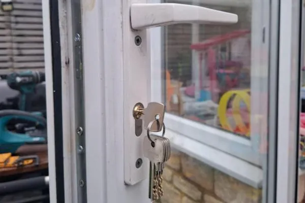 Replacement euro cylinder lock fitted to a white uPVC door with new keys.