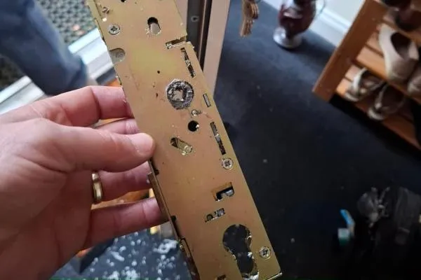 Damaged multipoint door lock gearbox held during inspection, illustrating residential locksmith services in Castle Ashby.